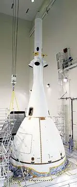 A white rocket is being built in the building.